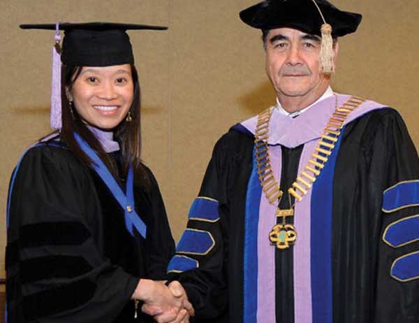 Christina Do is congratulated by President Ramon Baez