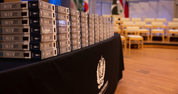 Stacked bibles displayed on a table in preparation for a School of Dentistry dedication ceremony