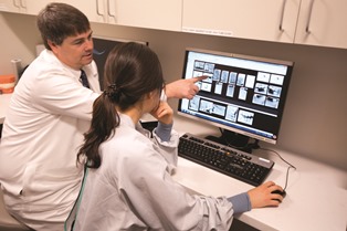 Dwight Rice, D.D.S., Associate Professor, instructs at a digital viewing/reading room workstation.