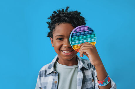 child with colorful toy in their hand
