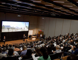 Large audience seated in an auditorium watching a presentation on implant dentistry during the 40th Anniversary Celebration..